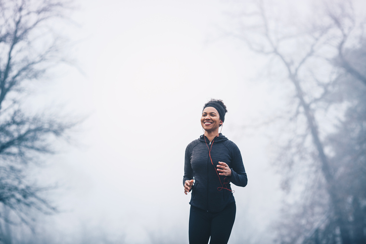 A woman jogging in the park forming healthy winter habits