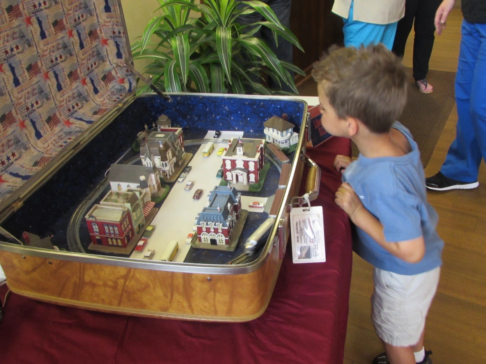 child looking at a model town set