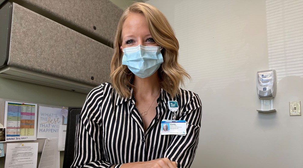 Doctor wearing mask smiles into camera