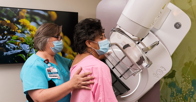 Vernese Butler receives mammogram as tech helps her